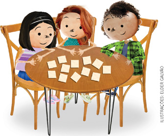 IMAGEM: três crianças estão sentadas ao redor de uma mesa com doze quadradinhos de papel sobre ela. FIM DA IMAGEM.