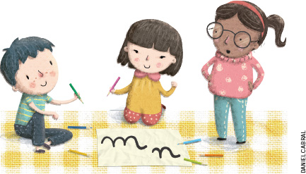 IMAGEM: duas crianças sentadas no chão escrevem as letras m e n em um papel. há lápis coloridos no chão ao redor delas. outra menina está em pé e observa a atividade, com cara de surpresa. FIM DA IMAGEM.