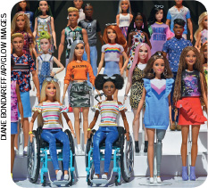 IMAGEM: conjunto de bonecas com diferentes características físicas e estilos. as duas bonecas da frente, uma loira de cabelos lisos e uma negra de cabelos cacheados, estão em cadeiras de rodas. FIM DA IMAGEM.
