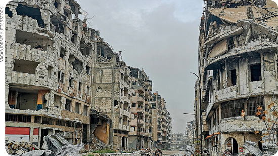 IMAGEM: escombros de prédios bombardeados. apenas suas estruturas são aparentna rua, há parte dos escombros. FIM DA IMAGEM.