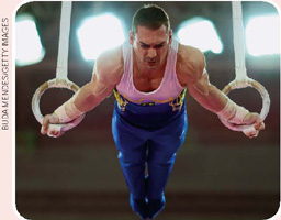 IMAGEM: o ginasta arthur zanetti com o corpo suspenso, apoiado pelas mãos em argolas, durante os jogos pan-americanos. FIM DA IMAGEM.