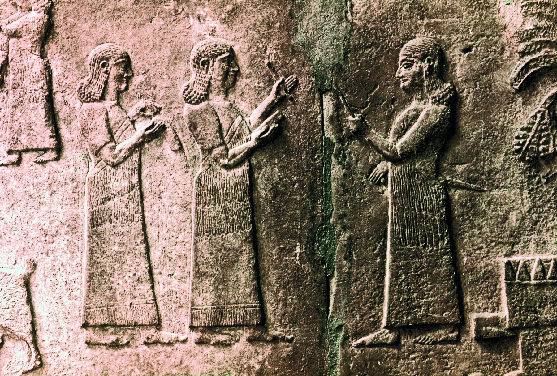 Relevo. Placa com a representação de homens vistos de perfil, vestindo longas túnicas, com as mãos flexionadas para frente, segurando objetos em forma de cunha.
