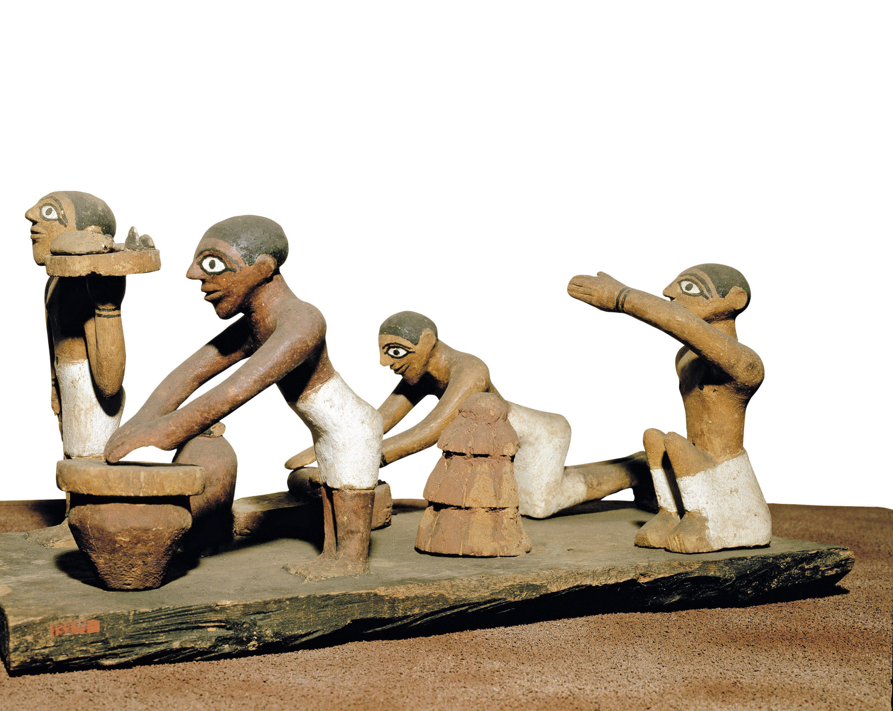 Escultura. Objeto de madeira representando quatro homens vestindo tecidos brancos ao redor de suas cinturas e peitos desnudos. Dois deles estão em pé, um ajoelhado e outro sentado com um dos braços erguido.
