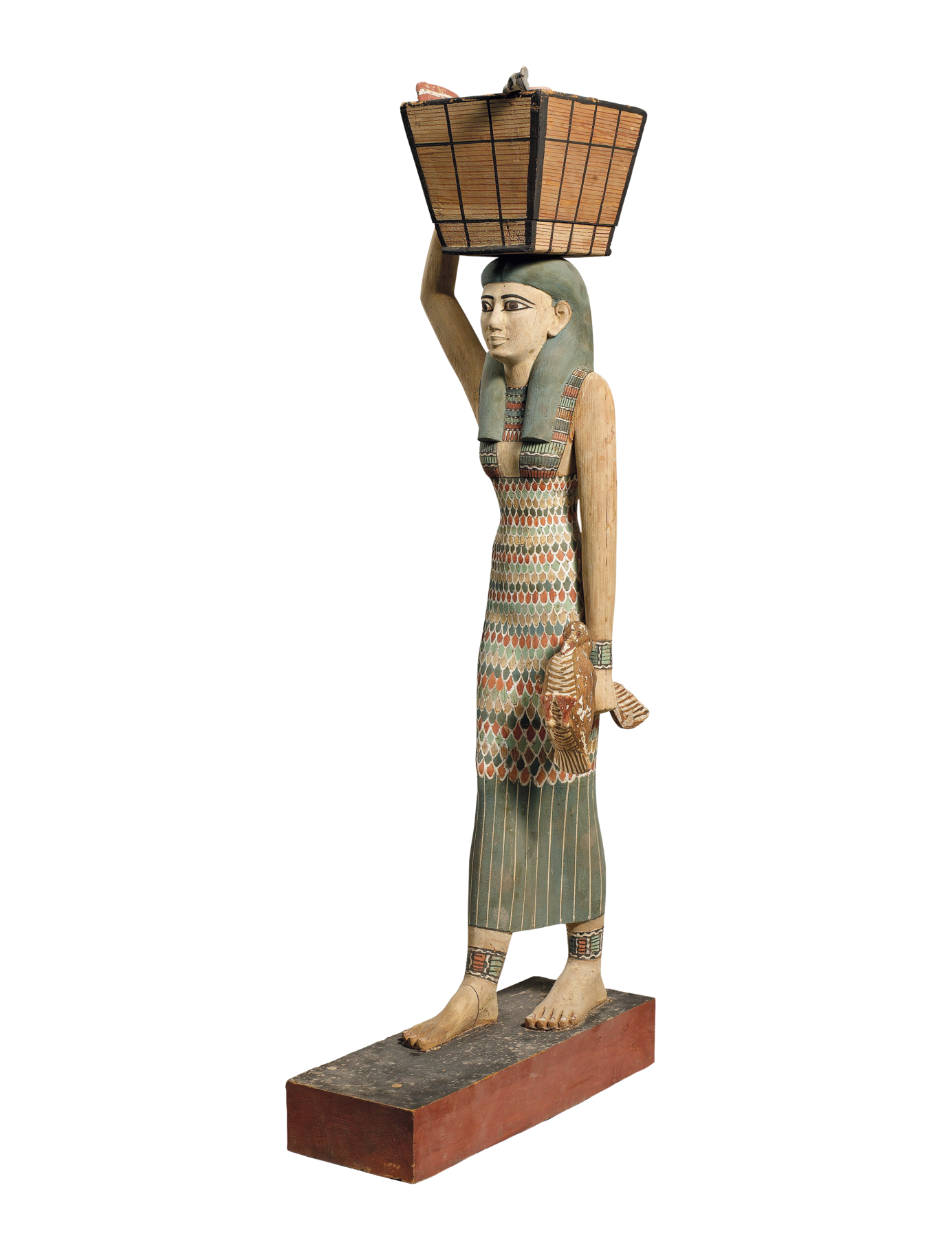 Estátua. Mulher egípcia, com longos cabelos escuros e lisos, usando um longo vestido colorido. Ela segura uma cesta com uma das mãos, apoiada em sua cabeça.