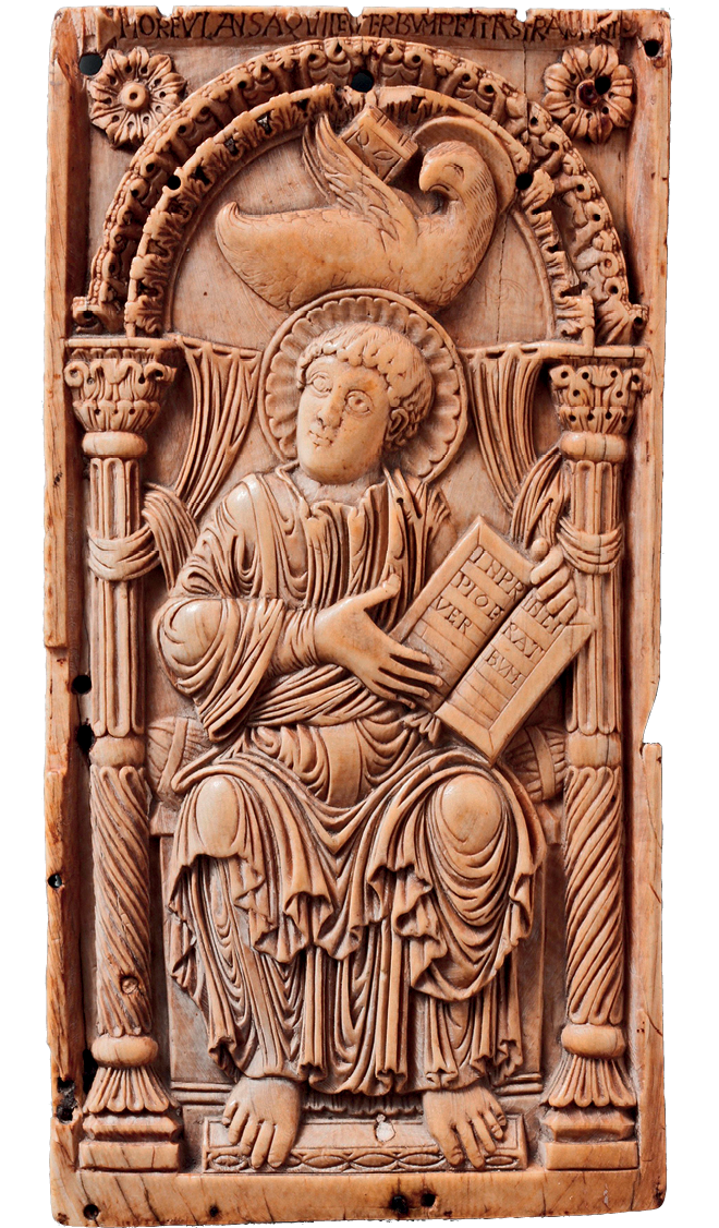 Relevo. Placa esculpida em pedra, representando um homem vestindo uma túnica, sentado, segurando um livro com as mãos. Tem uma auréola ao redor de sua cabeça e, acima, uma pomba. Nas laterais há colunas decoradas.