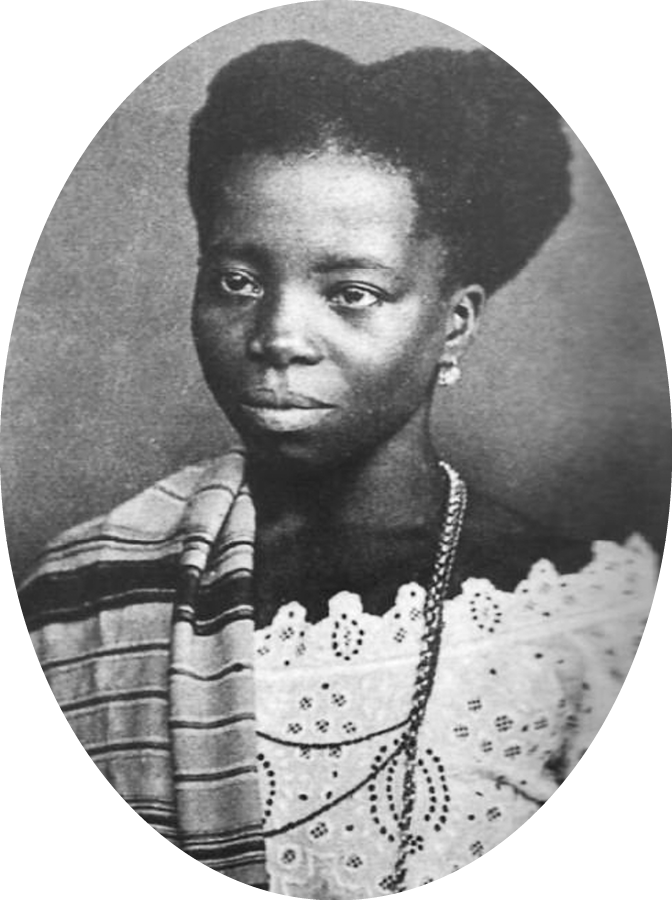 Fotografia em preto e branco. Retrato de uma mulher negra, vista de frente, com cabelos crespos, trajando uma vestimenta predominantemente clara, colar e um lenço listrado sobre os ombros.