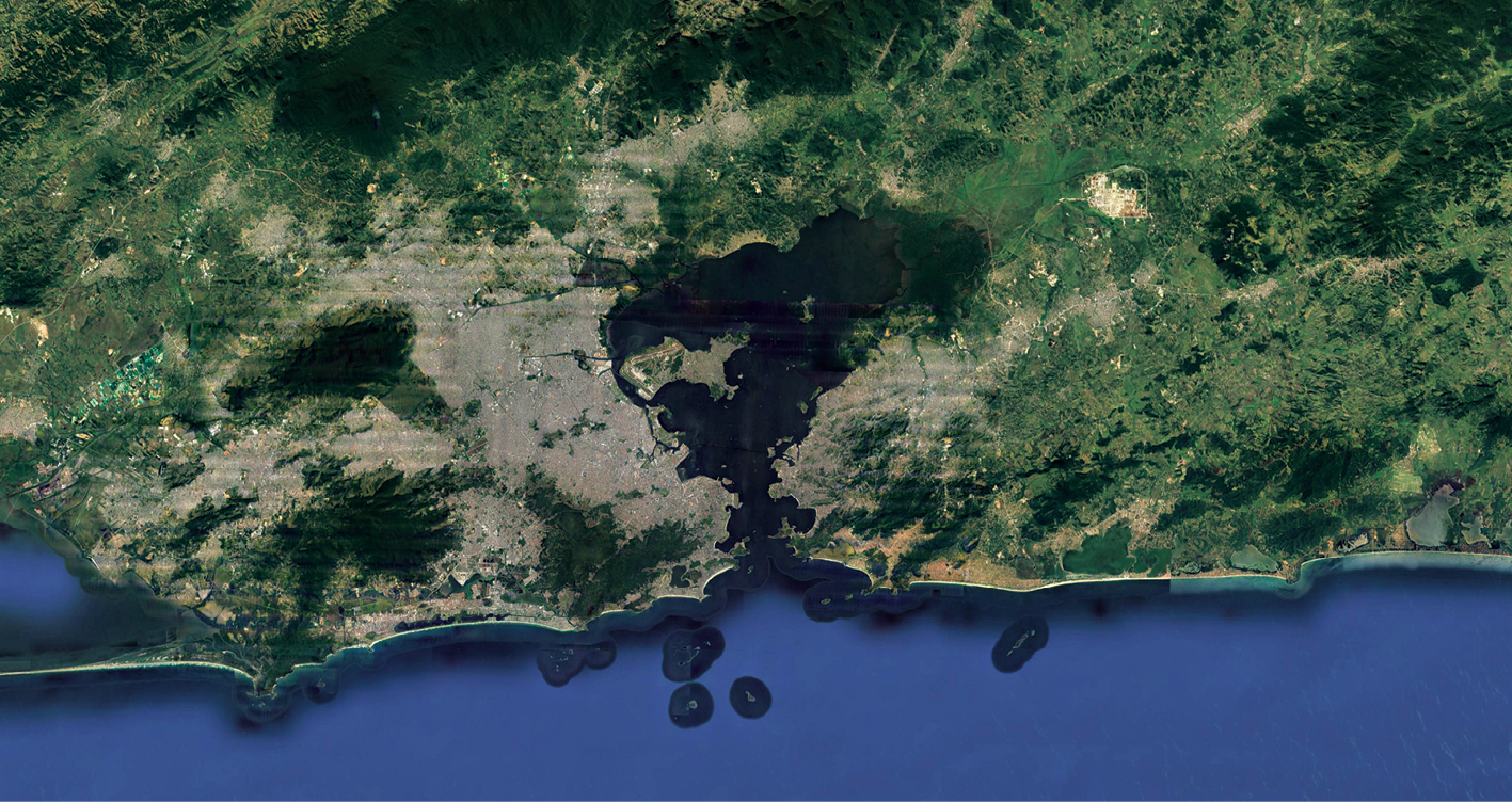 Imagem de satélite. Parte da cidade do Rio de Janeiro.  No primeiro plano, mar e alguns morros; na sequência, faixa de areia, área construída, área com vegetação, baías.