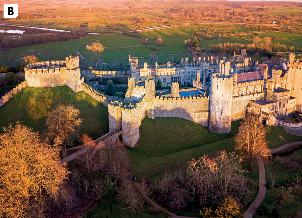 Fotografia B. Vista aérea de uma superfície montanhosa ocupada por um grande castelo de pedra, composto por muros, torres, corredores e salões. Ao redor, superfície coberta por vegetação rasteira e fragmentos florestais.