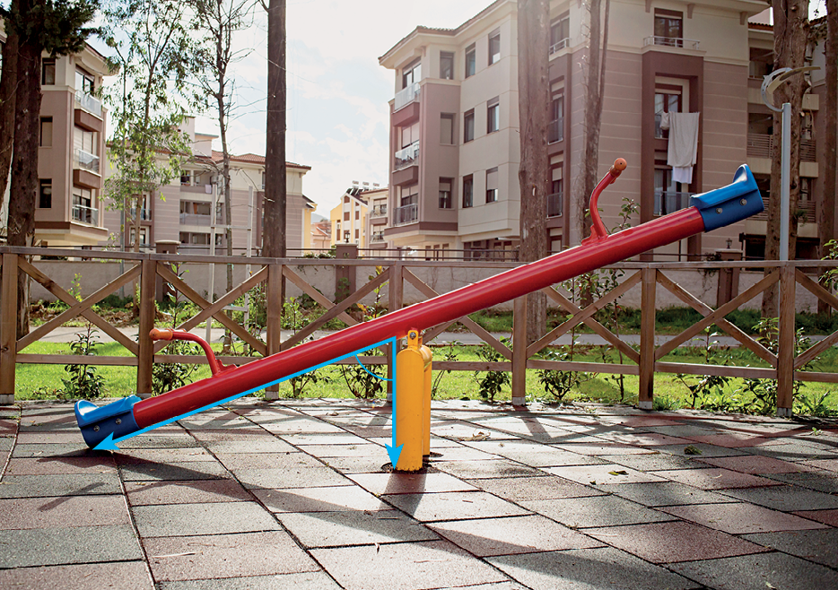 Fotografia.
Gangorra vermelha e azul, localizada em um parque. 
Um lado está para cima e outro lado para baixo. O encontro do lado para baixo e o mastro no centro representa uma semirreta vertical e outra diagonal.