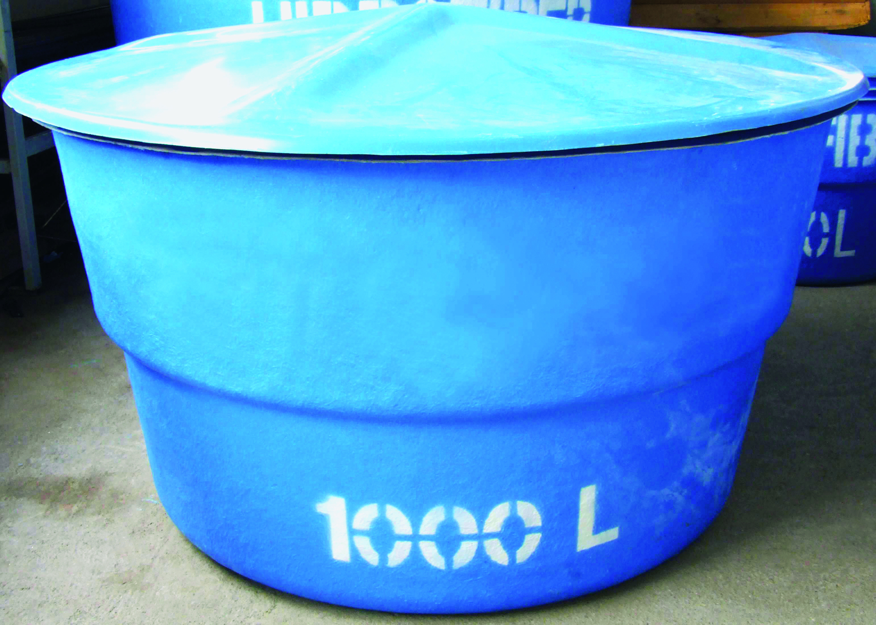 Fotografia. Caixa d’água azul com capacidade de 1000 litros.