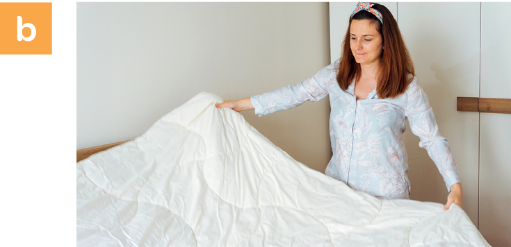 Fotografia. Letra b. Uma mulher está estendendo um lençol branco sobre a cama.