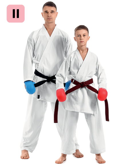Fotografia. Número 2. Um homem e um menino estão usando kimono branco e uma faixa preta na cintura. O homem usa luvas azuis e o menino usa luvas vermelhas. Eles estão em pé com os braços ao lado do corpo.