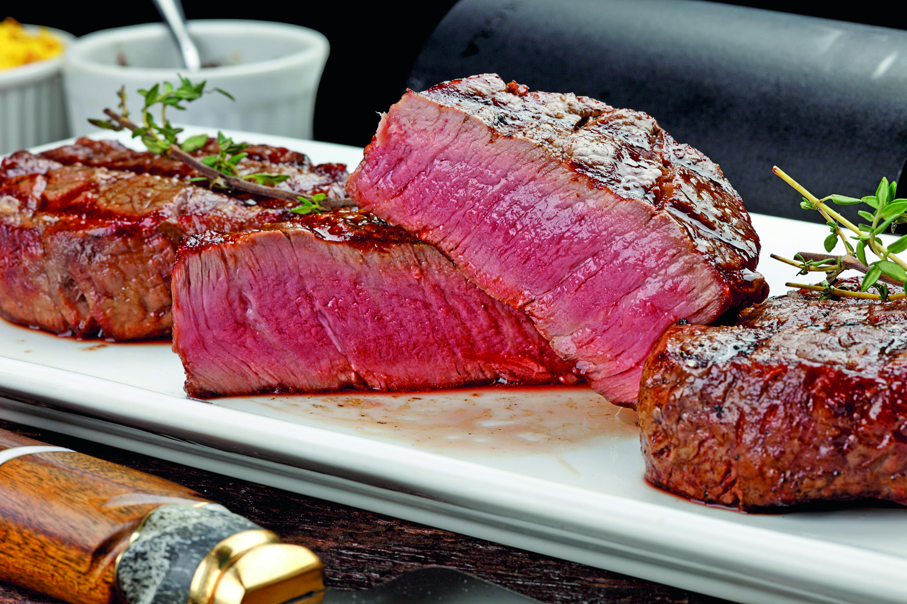 Fotografia. Pedaços de carne vermelha sobre um prato branco.