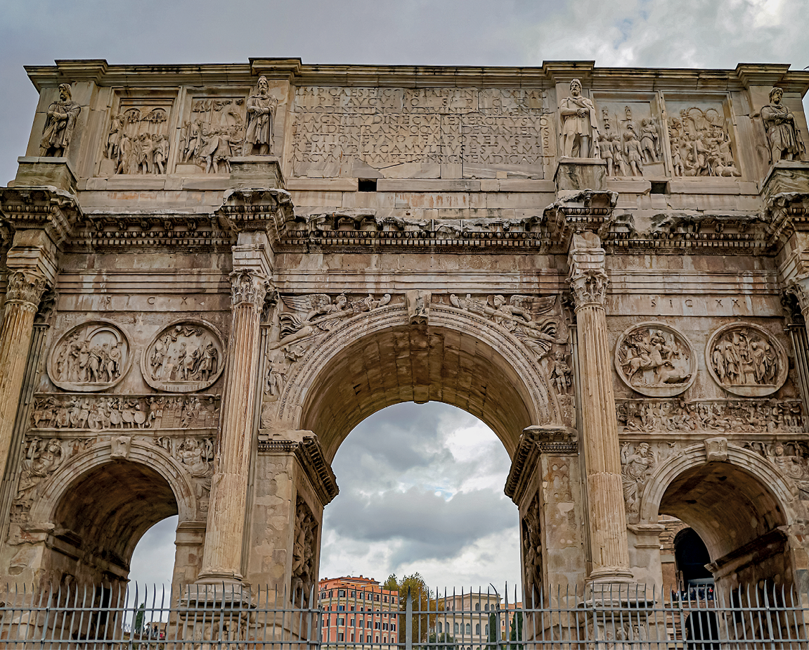 Fotografia. Arco de Titus, um arco em tons de bege com ornamentos esculpidos em pedra.