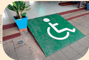IMAGEM: uma rampa ligando o chão a um nível mais alto, substituindo os degraus. ela tem um símbolo desenhado representando uma pessoa em uma cadeira de rodas. FIM DA IMAGEM.