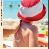 IMAGEM: pessoa aplica protetor solar nas costas de uma criança que usa um chapéu. FIM DA IMAGEM.