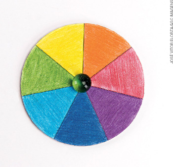 IMAGEM: disco de papel colorido, dividido em sete pedaços, cada um pintado com uma cor do arco-íris. FIM DA IMAGEM.