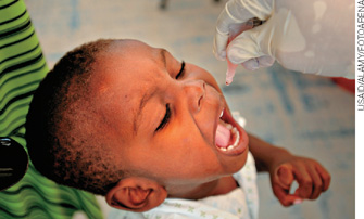 IMAGEM: criança tomando a vacina oral contra a poliomielite. FIM DA IMAGEM.