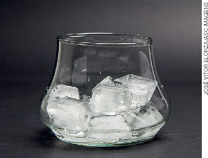 IMAGEM: recipiente cilíndrico de vidro contendo vários cubos de gelo. FIM DA IMAGEM.