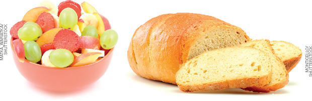 IMAGEM: recipiente plástico com as frutas: uva, maçã, morango e banana e, ao lado está um pão caseiro do qual foram cortadas algumas fatias. FIM DA IMAGEM.