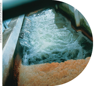 IMAGEM: tanque retangular usado no processo de flotação onde se nota a água agitada formando uma espécie de espuma em seu interior. FIM DA IMAGEM.