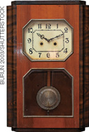 IMAGEM: Um relógio mecânico de madeira, com um pêndulo na parte inferior. FIM DA IMAGEM.