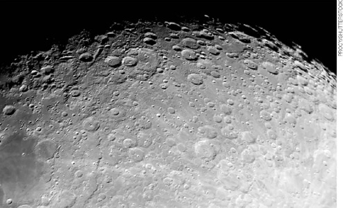 IMAGEM: superfície da lua, possuindo diversas crateras em toda sua extensão. FIM DA IMAGEM.