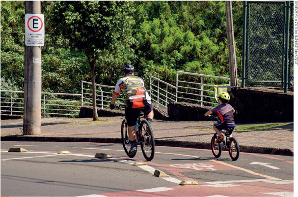 IMAGEM: um adulto e uma criança andando de bicicleta na ciclovia. FIM DA IMAGEM.