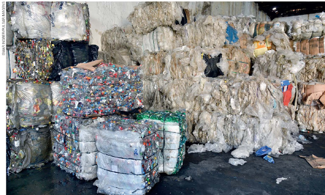 IMAGEM: blocos de materiais recicláveis empilhados. FIM DA IMAGEM.