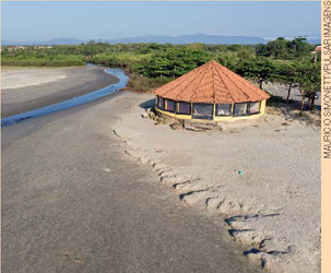 IMAGEM: uma casinha na areia da praia, nota-se que a água não chega até a construção. FIM DA IMAGEM.
