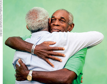 IMAGEM: dois homens idosos se abraçam. FIM DA IMAGEM.