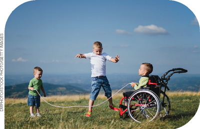 IMAGEM: um menino em cadeira de rodas e um menino pequeno batem uma corda para um terceiro menino pular. FIM DA IMAGEM.