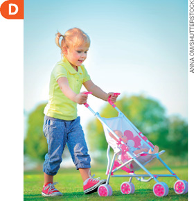 IMAGEM: d. fotografia colorida de 2020 mostra uma menina carregando uma boneca em um carrinho moderno em um parque. FIM DA IMAGEM.