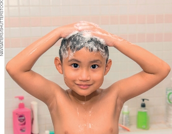 IMAGEM: um menino lava o cabelo no banho. FIM DA IMAGEM.