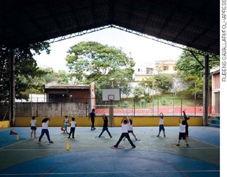 IMAGEM: quadra de esportes de uma escola, onde um grupo de dez crianças se exercita. FIM DA IMAGEM.