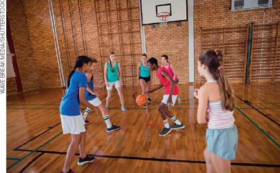 IMAGEM: sete crianças jogam basquete em uma quadra. FIM DA IMAGEM.