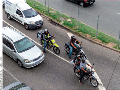IMAGEM: carros e motos em uma rua movimentada. FIM DA IMAGEM.