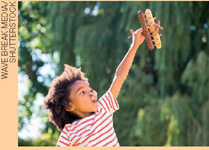 IMAGEM: garoto brinca ao ar livre com um avião de brinquedo. FIM DA IMAGEM.