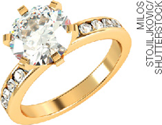 IMAGEM: um anel de ouro com um grande diamante em cima e outros menores nas laterais. FIM DA IMAGEM.
