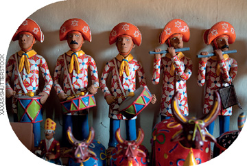 IMAGEM: esculturas de barro pintadas com cores fortes no formato de touros de diversos tamanhos e de homens tocando instrumentos com chapéu e vestes típicas do nordeste do brasil. FIM DA IMAGEM.