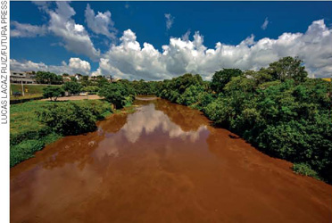 IMAGEM: fotografia do curso de um rio que teve as águas modificadas pelo lançamento de lama e rejeitos de mineração. FIM DA IMAGEM.
