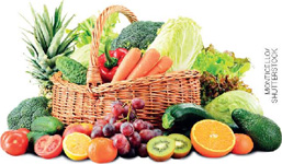 IMAGEM: uma cesta de palha com legumes, como cenouras, pepinos, brócolis, e frutas, como kiwis, laranjas, abacates e tomates. FIM DA IMAGEM.
