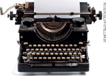 IMAGEM: uma máquina de escrever antiga. possui teclas como as de um teclado de computador. na parte superior, um cilindro com papel e uma alavanca. FIM DA IMAGEM.