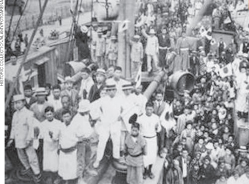 IMAGEM: fotografia antiga mostra um navio com muitas pessoas em seu convés. FIM DA IMAGEM.