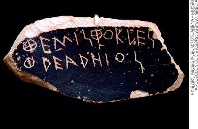 IMAGEM: fragmento de cerâmica com um nome escrito de maneira rudimentar. FIM DA IMAGEM.