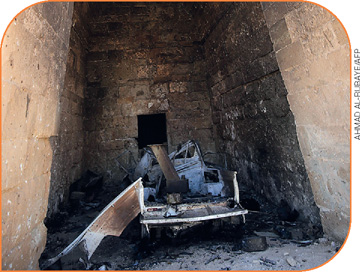IMAGEM: cavidade triangular construída com pedras em bloco. em seu interior, há um objeto destruído após a explosão de uma bomba. FIM DA IMAGEM.