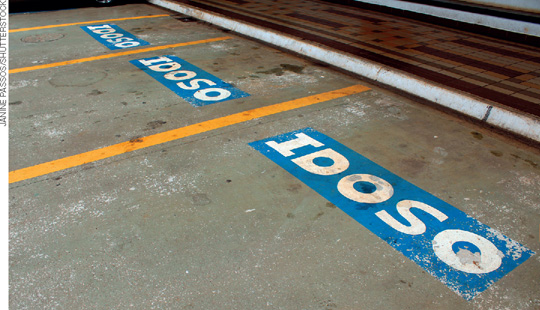 IMAGEM: a palavra idoso está pintada no chão de um estacionamento, separadas por três linhas retas. FIM DA IMAGEM.