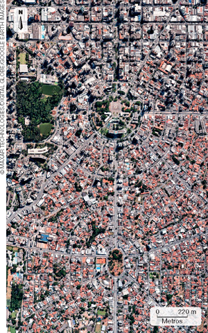 IMAGEM: registro aéreo de duas praças em formas circulares têm ruas simétricas que as encontram perfeitamente, ao redor, há inúmeras casas formando quarteirões. FIM DA IMAGEM.