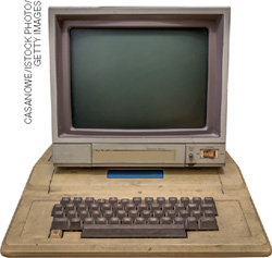 IMAGEM: computador antigo com um monitor quadrado e um teclado sobre uma estrutura de plástico espaçosa. FIM DA IMAGEM.