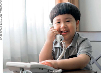 IMAGEM: um menino asiático fala ao telefone. FIM DA IMAGEM.